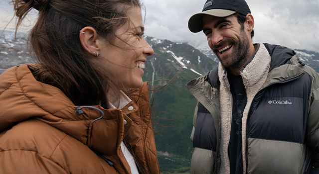 A couple in outdoor gear smiling.