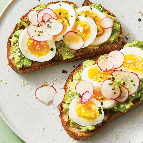 Smashed Avocado Toast with Egg on a white plate