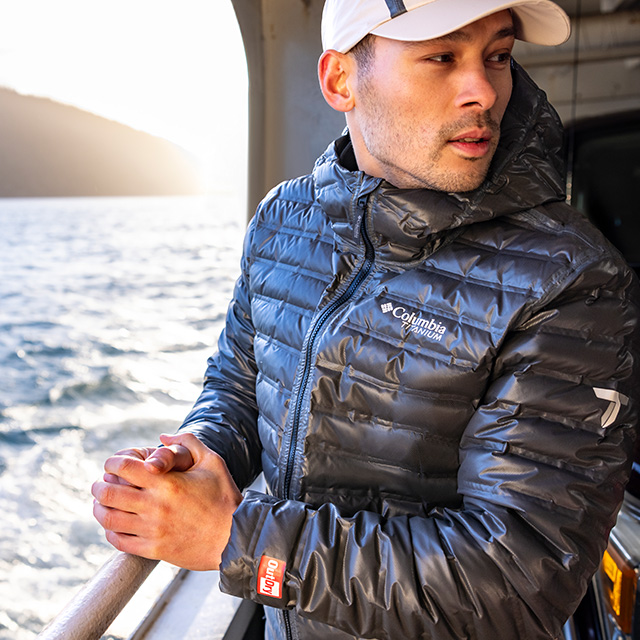 A man in an outdry extreme rain coat on a ferry boat.