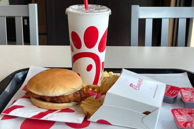 Chick-fil-A meal on tray with chicken sandwich, waffle fries, drink and three ketchups.