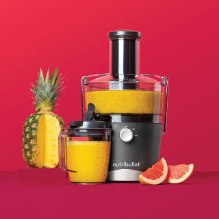 nutribullet juicer with sliced pineapple and orange slices.