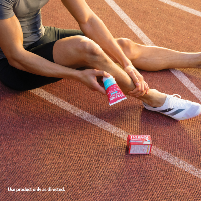 athlete applying Tylenol Precise cooling pain relieving cream to leg.