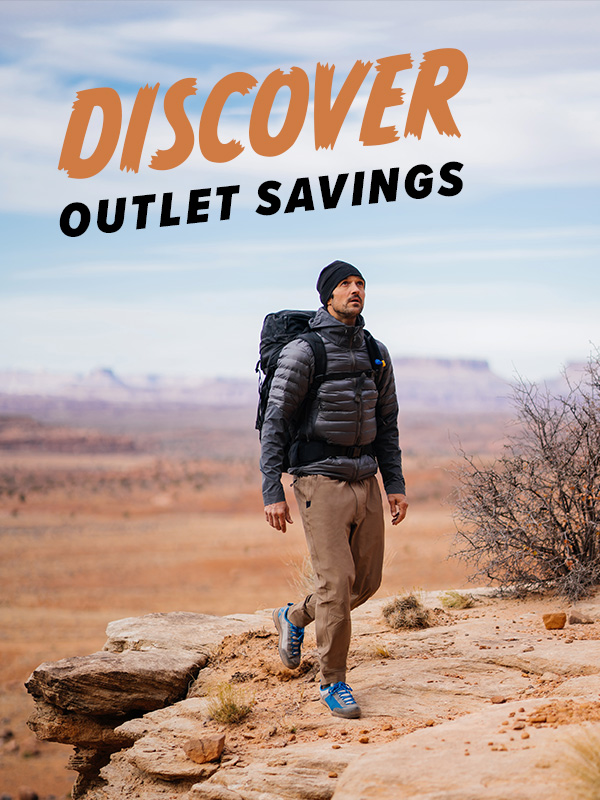 Man hiking through a sunny Utah while wearing Beyond Clothing. Text overlay Discover, Outlet Savings.