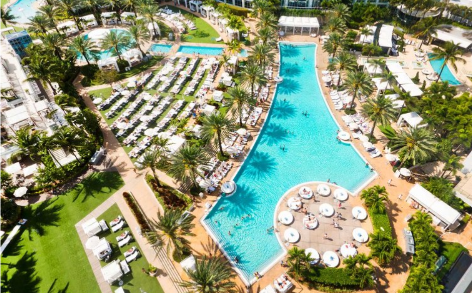 An aerial view of the resort-style pool, chairs and palm trees at Fontainebleau Miami Beach