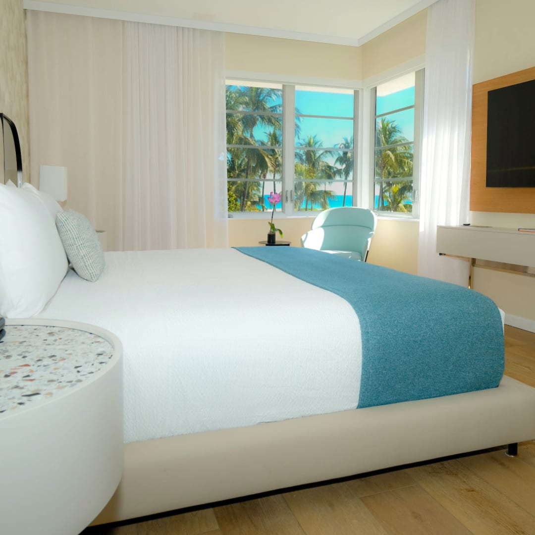 An interior shot of a hotel room with a view of the ocean 