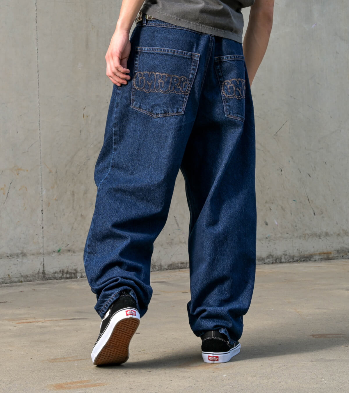 Man wearing baggy blue denim Empyre Ultra Loose skate pants