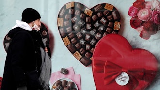 A man passes a Fannie May chocolate shop, Chicago, Feb. 14, 2021.