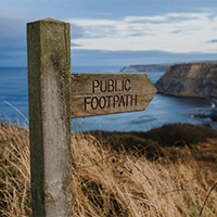 public footpath sign at top of mountain peak