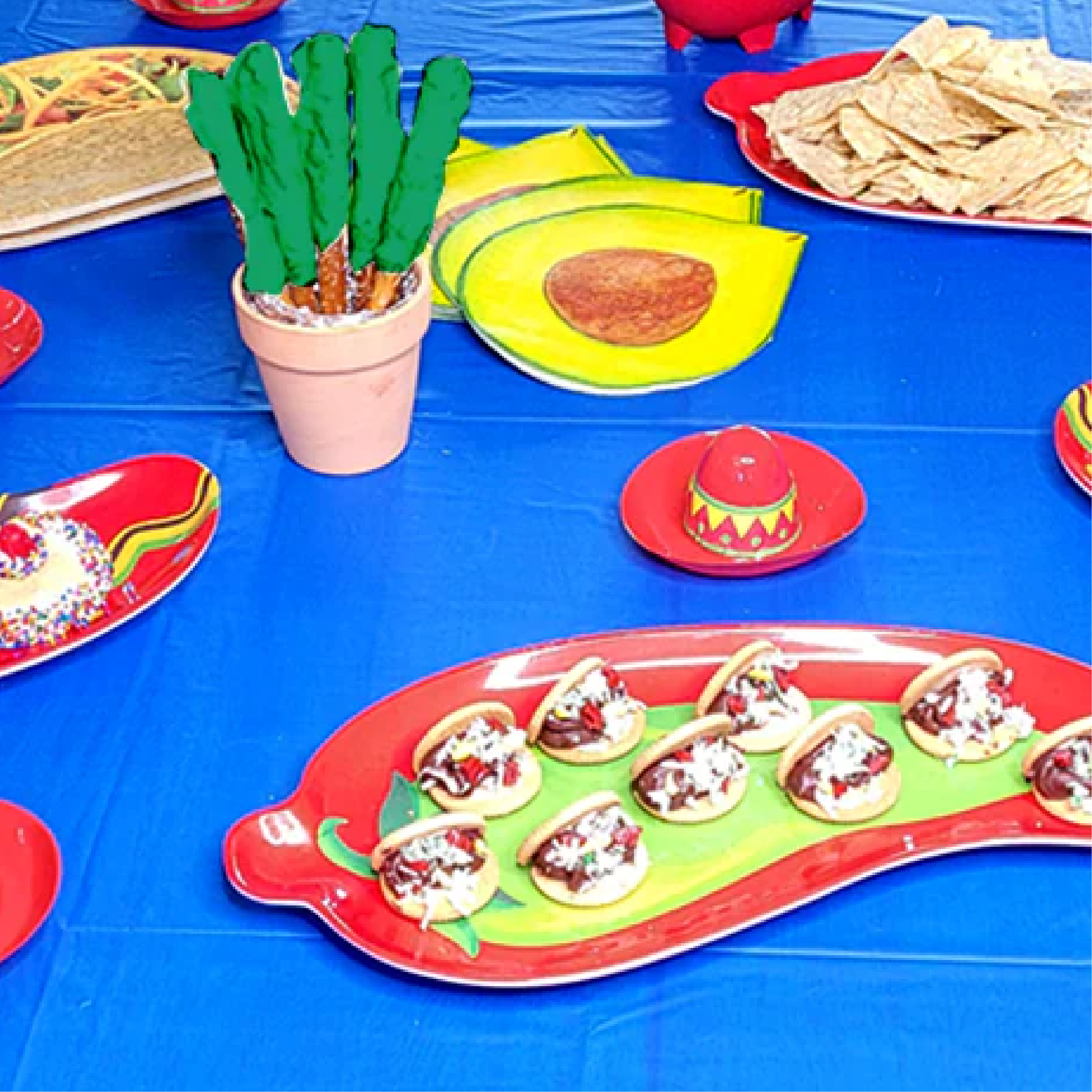 Blog idea: table with blue table cover, cactus banner, Cinco De Mayo desserts, themed cups, plates, napkins, and mini hats