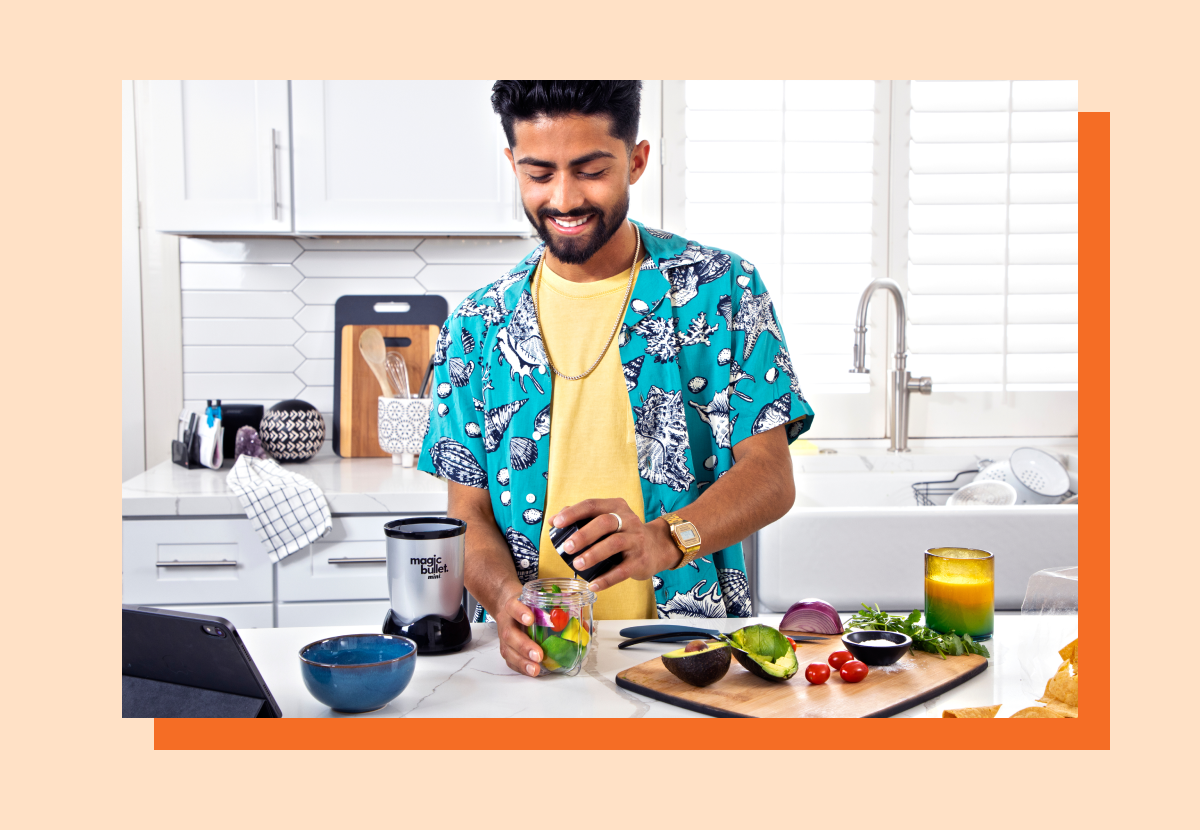 Man blending vegetables and fruits with the magic bullet Mini in a kitchen 