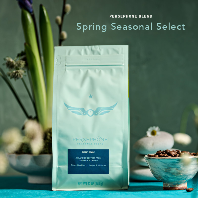 Persephone Blend coffee bag on a soft blue background with spring florals surrounding