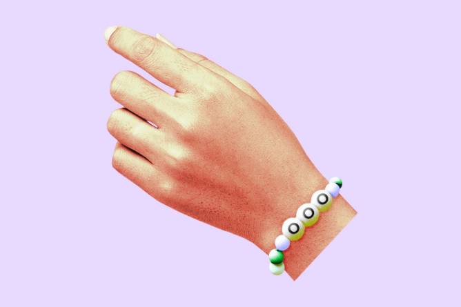 A hand with a friendship bracelet that says "OOO".