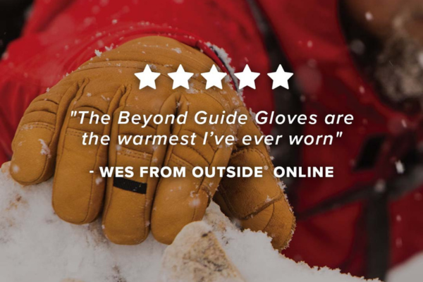 5 star review saying "The Beyond Guide Gloves are the warmest I've ever worn" with a background of the Timber Guide Glove reaching up onto a snowy rock.