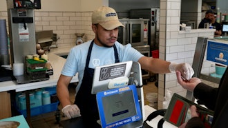 An employee collects payment at an Auntie Anne's and Cinnabon store in Livermore, Calif., March 28, 2024.