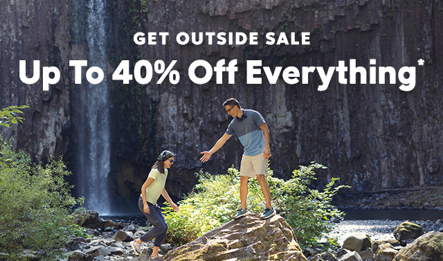 Two people hiking through a green and rocky landscape. Get Outside Sale, Save On Everything overlays the image.